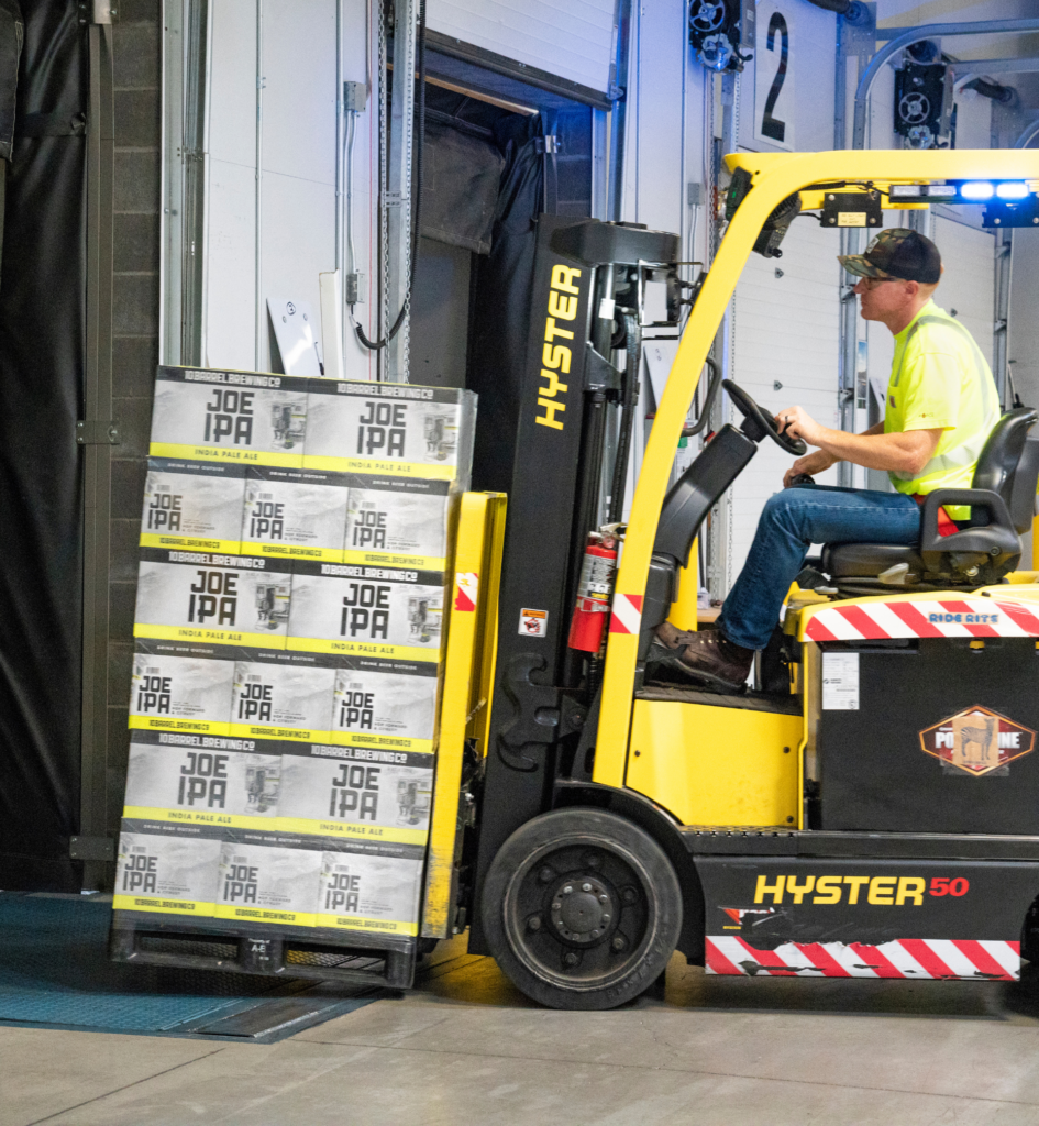 APF staff member on a forklift in a cold storage warehouse