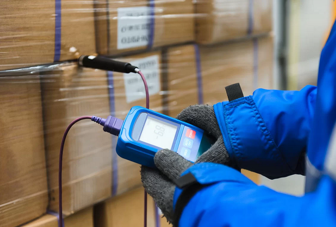APF staff member using thermometer in cold storage facility